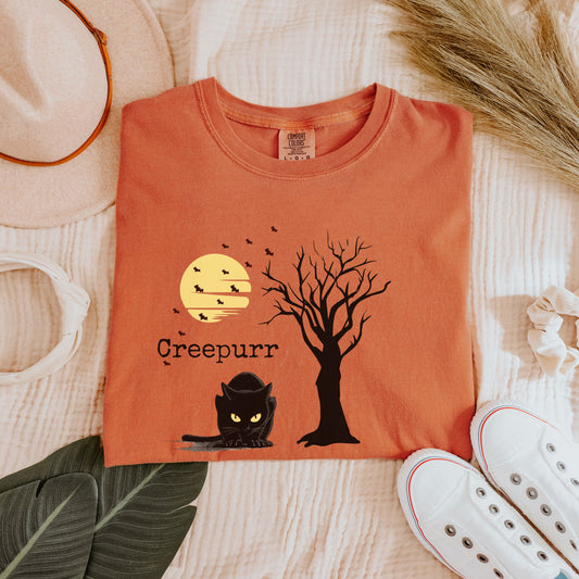 Flat lay black cat Halloween tee with moon and bats, spooky gothic graphic shirt styled for fall.